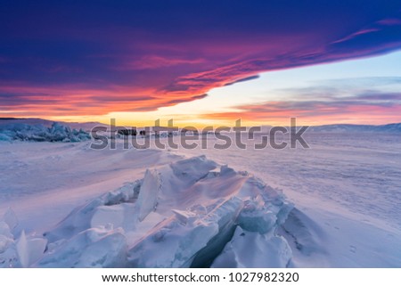 Winter landscape in sunset, Cracked frozen lake covered of snow at lake Baikal in Russia with beautiful sunset sky