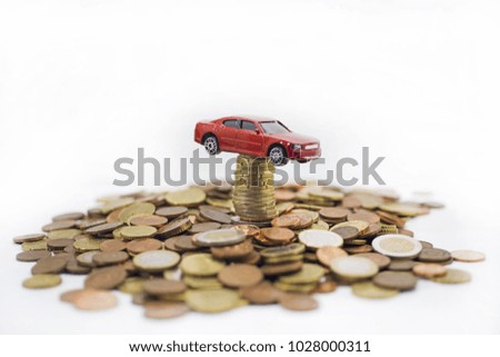 Small red car on coins. Abstract macro photo.