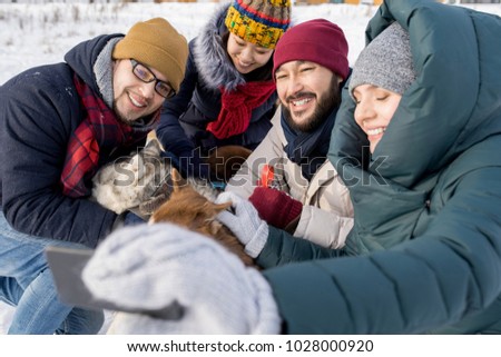 Portrait of two young couples taking selfie with dogs enjoying nice winter day outdoors