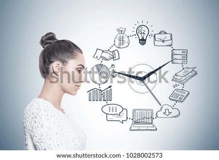 Side view of a calm and beautiful young european woman with a bun wearing a white sweater. A gray wall background with time management icons