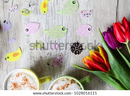 Tulips on wooden with two cups of coffee. Invitation postcard for mother's day or international women's day. Spring paper colorful birds. Handmade origami. Punchy pastels. Easter pictures