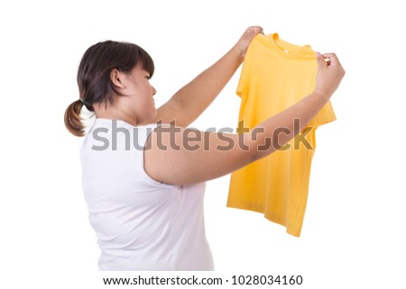 Fat asian woman trying to wear small size of yellow t-shirt isolated on white background. Fat and Healthcare concept