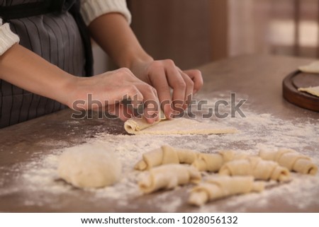 Woman preparing croissants on table