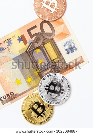 Financial concept with image of bitcoins on fifty euro banknote. Traditional money versus cryptocurrency concept.