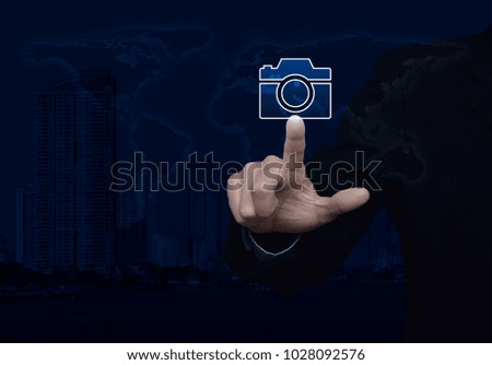 Businessman pressing camera flat icon over world map and modern city tower, Business camera service concept, Elements of this image furnished by NASA