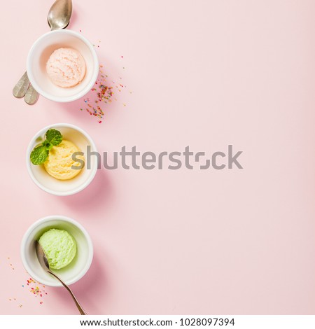 Top view of ice cream in white bowls on pink shabby chic vintage background. Pink (strawberry), yellow (mango or banana) and green (lime, green tea or pistachio).