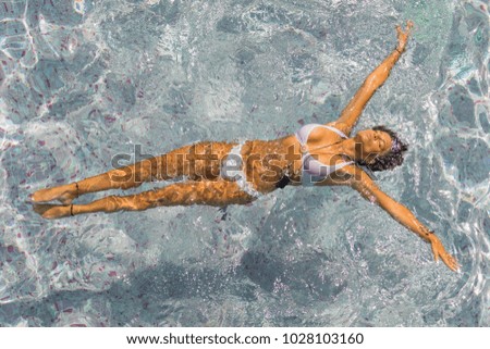 Young woman relaxing in the pool - top view