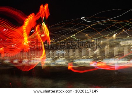 Abstract long exposured lines at night. The red shaped figure is looks like a horse head.
