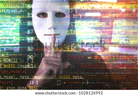 Hacker in mask showing silence gesture and code on blurred background. Concept of cyber attack and security 