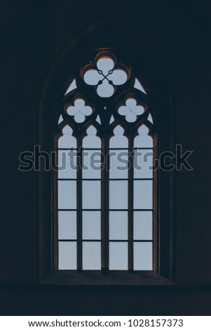 Inverted silhouette of large medieval window in backlight in Gothic style.