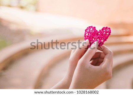 Red heart shape in the woman hands.