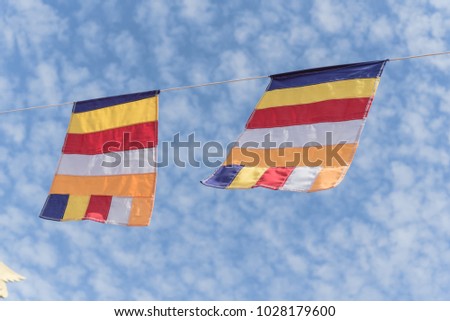 Colorful hanging line Buddhist prayer flags against Altocumulus cloud sky. Waving  holy sacred five colors flags as abstract background with copy space. Religious holiday decoration.