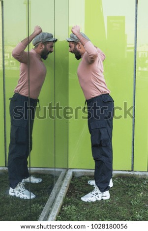 Handsome Indian man posing in front of a mirror. Street fashion and style.