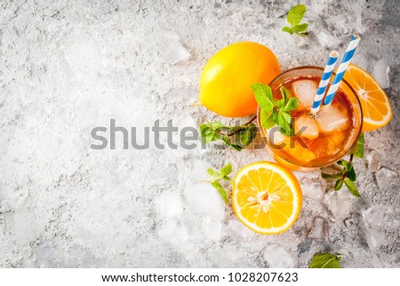 Cold summer drink. iced tea with lemon and mint, on grey stone background.  Copy space top view