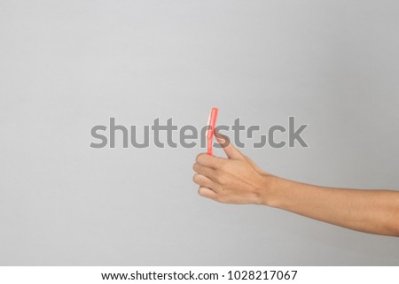 Hand is holding a pink razor blade isolated on white background.