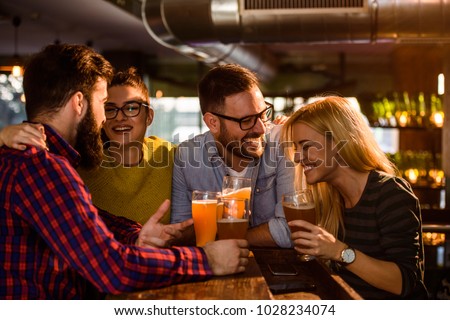Friends in the Pub. Drinking beer, talking, having fun. Royalty-Free Stock Photo #1028234074