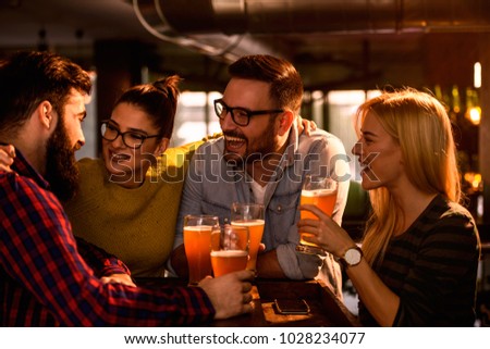 Friends in the Pub. Drinking beer, talking, having fun. Royalty-Free Stock Photo #1028234077