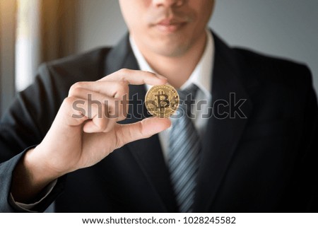 Golden bitcoin in hand of business man with black suit,Digitall symbol of a new virtual currency