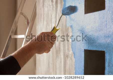 Repair and home renovation concept, close up of hand  is painting a wall Royalty-Free Stock Photo #1028289652