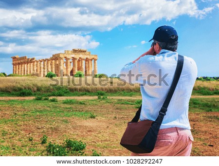 Man taking photos of Doric temple of Hera at Selinunte in Sicily, Italy
