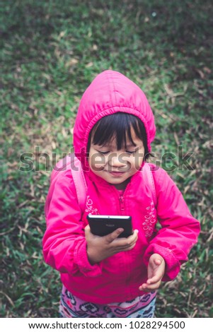 Cute  girl student wear topcoat looking smartphone 