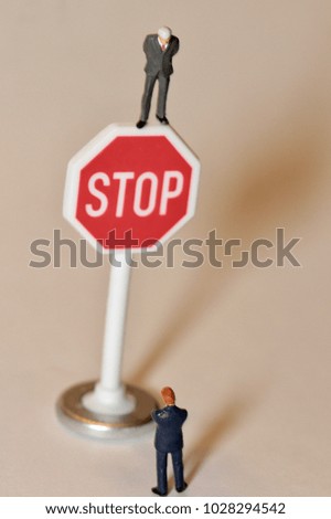 businessman in miniature and a stop sign