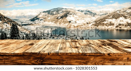 Table background of free space for your decoration and sunny landscape of winter mountains and lake. Photo make in Alps Zell am See. 