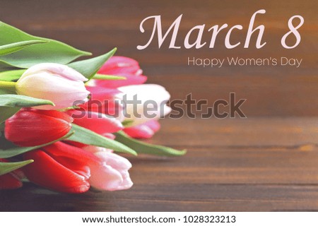 Happy woman's day. March 8. Tulips on a brown wooden table