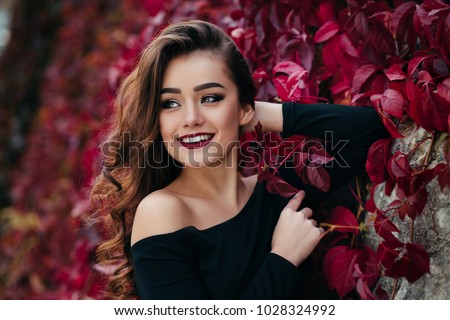The beautiful girl stands near walll with leaves Royalty-Free Stock Photo #1028324992