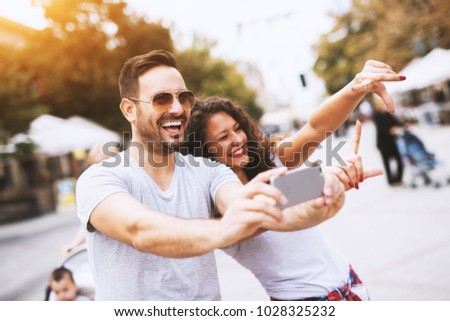 Man with beard and sunglasses smiling while taking a photo with a beautiful young girl. 