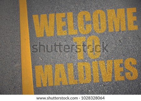 asphalt road with text welcome to maldives near yellow line. concept