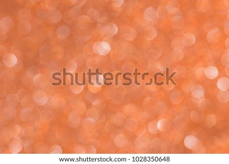 Optical bokeh from holographic foil. Orange background.