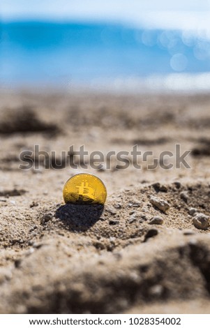Bitcoin. Bitcoin on golden sand, in background sea. Concept freelance, stock exchange