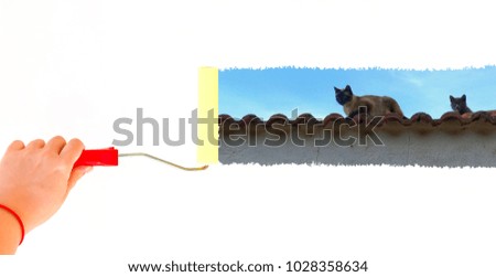 person painting two cats on a roof top on a white wall with a roller brush