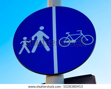 Pedestrian crossing and bycicle  path traffic sign against beautiful blue sky.