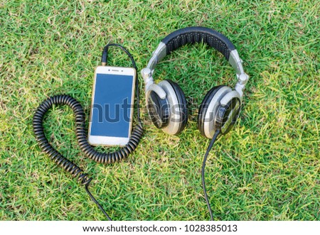 Headphones with the phone on the grass, techno, music, relaxation