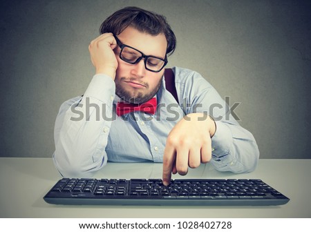 Young obese man sitting at workplace and procrastinating being lazy and distracted.  Royalty-Free Stock Photo #1028402728