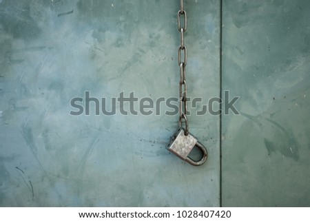 Rusty Metal Chains and Lock Key on Vintage Metal Green Wall