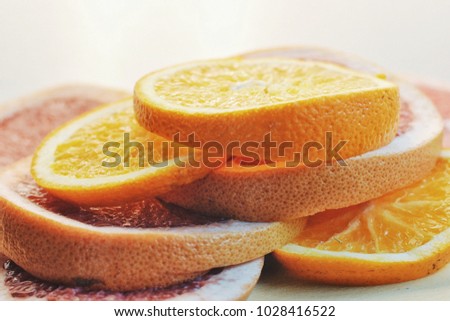 Slices of fruits on the table. Fruit tower. Grapefruits and oranges on white background