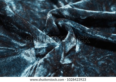 Close-up waves of dark blue velvet background. Drapery aqua-colored fabric, luxury texture