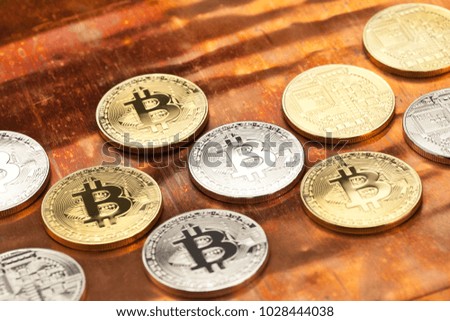 Silver and gold bitcoins on a bright copper background.