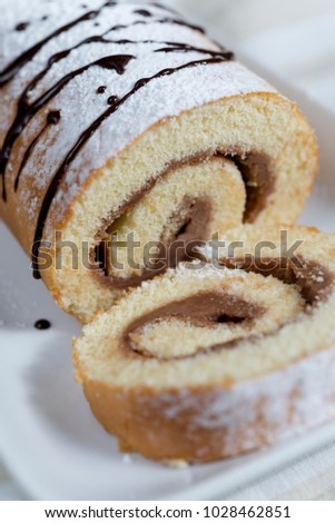 sweet roll of sponge cake with cream chocolate and mascarpone