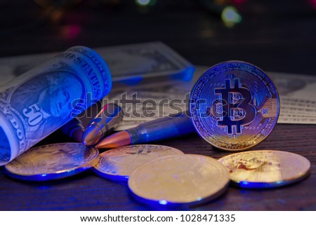 Bitcoins and dollar banknotes on a wooden table with UV light