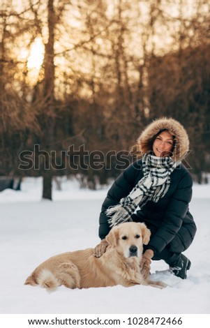 Image of smiling girl on walk with dog on background of trees