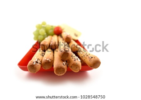 Salty sticks with garnish stock images. Salty sticks on a white background. Salty snack on a red tray. Big salty sticks
