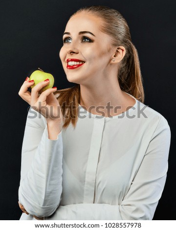 Portrait Of A Young Woman Holding Green Apple against a black background