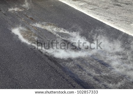 Hot smoking asphalt at road construction site