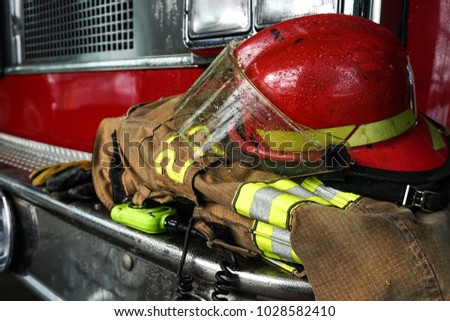 Firefighter gears on the bumper of the fire truck Royalty-Free Stock Photo #1028582410