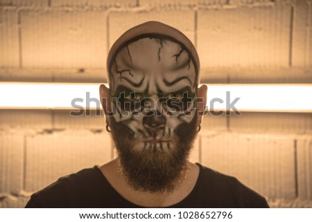 Make up the skull. A bald guy with a beard with a makeup skull. A man with a makeup skull. A terrible portrait of a man. Portrait of a guy skeleton