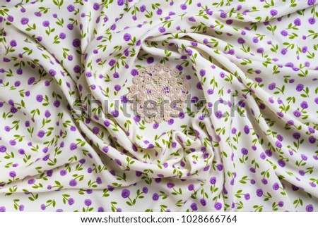 Silk fabric tapestry with floral texture and white lace of crochet napkins in retro style
